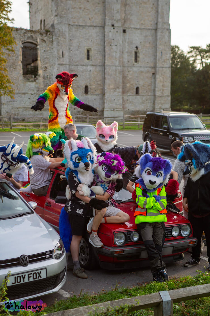 A group photo with everyone sat on a red Volkswagen Golf GTI